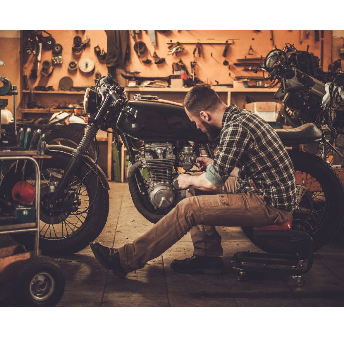 greasemonkey guy working on motorcycle engine needs scrubbing soap