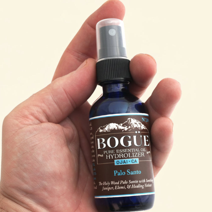 palo santo essential oil spray in hand 2oz for size