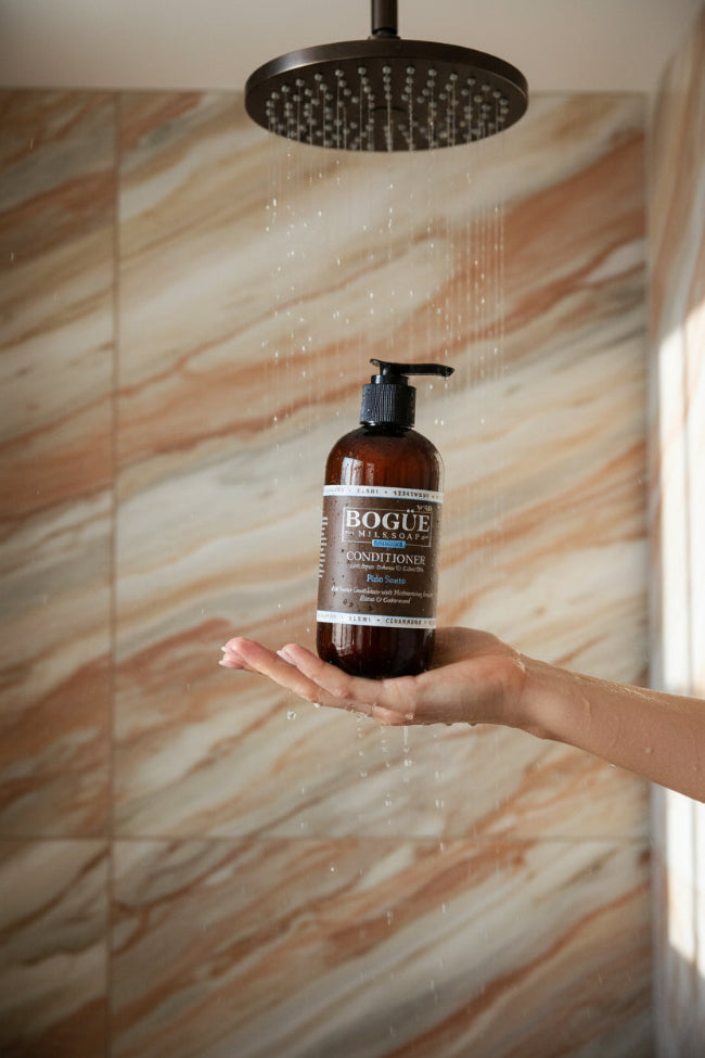 palo santo conditioner in hand in shower