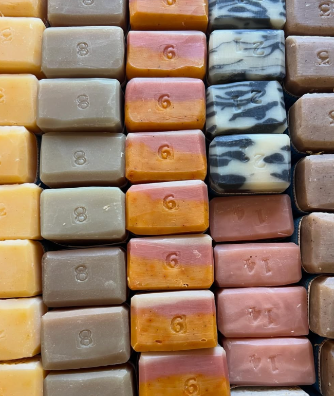 Rows of goat milk soap with clays and botanicals and essential oils