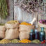 Healing herbs in hessian bags and bottles of essential oil near